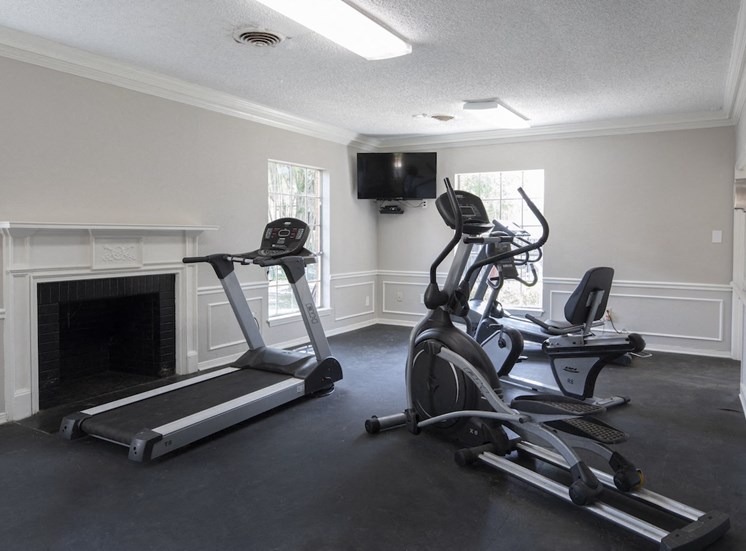 fitness center with cardio equipment and television