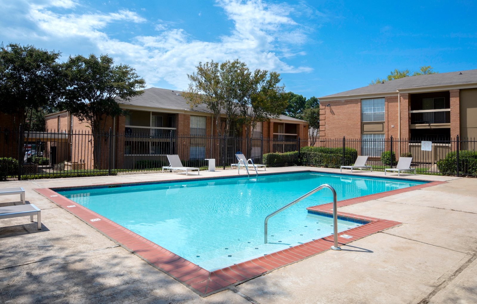 Swimming pool and sundeck with ample lounge furniture at Hampton House Apartments