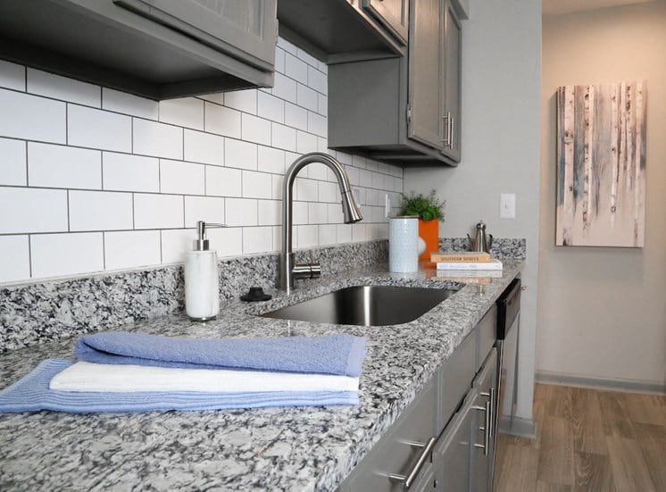 sleek granite countertops in kitchen surrounding stainless steel sink