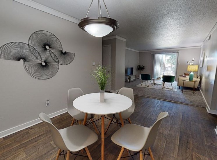 Dining area with pendant lighting, wood-style floors, and model dining furniture at Reserve at Midtown Apartments in Tallahassee, Florida 32303