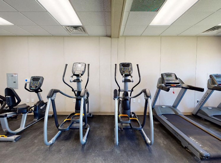 Teadmills, eliptical trainers, bike, and rowing machine in fitness center at Reserve at Midtown Apartments in Tallahassee, Florida 32303