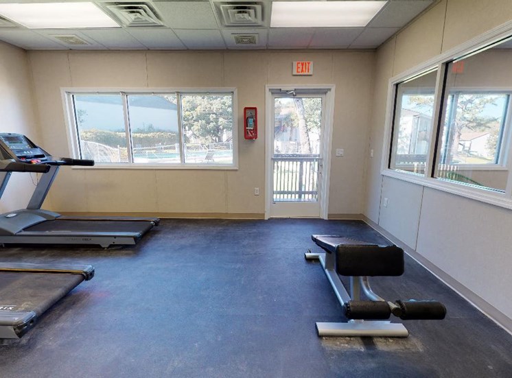 Fitness center with treadmills and work out bench at Reserve at Midtown Apartments in Tallahassee, Florida 32303