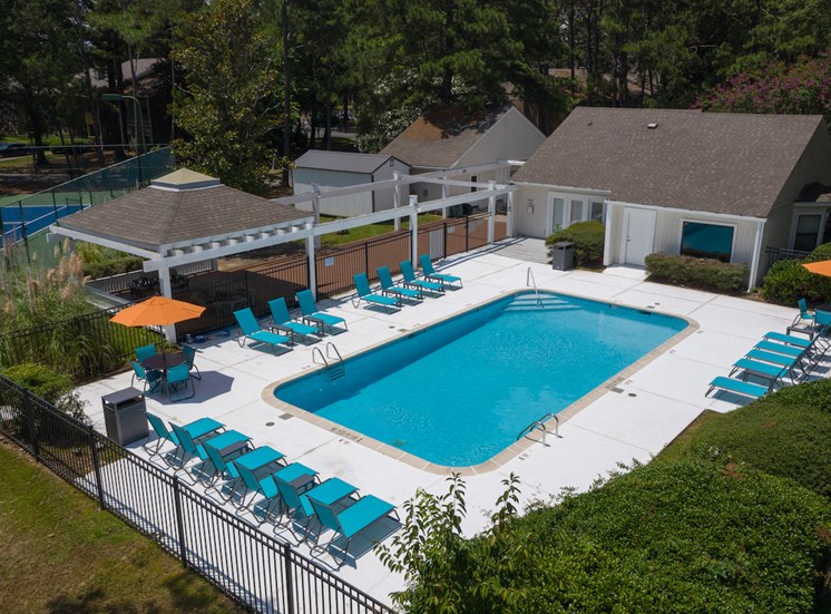 rows of lounge chairs, picnic tables with umbrellas, and pool at Zelda Pointe Apartments