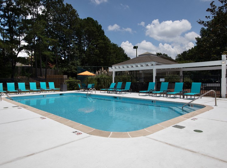 large pool and spacious sundeck with lounge chairs and pergola area