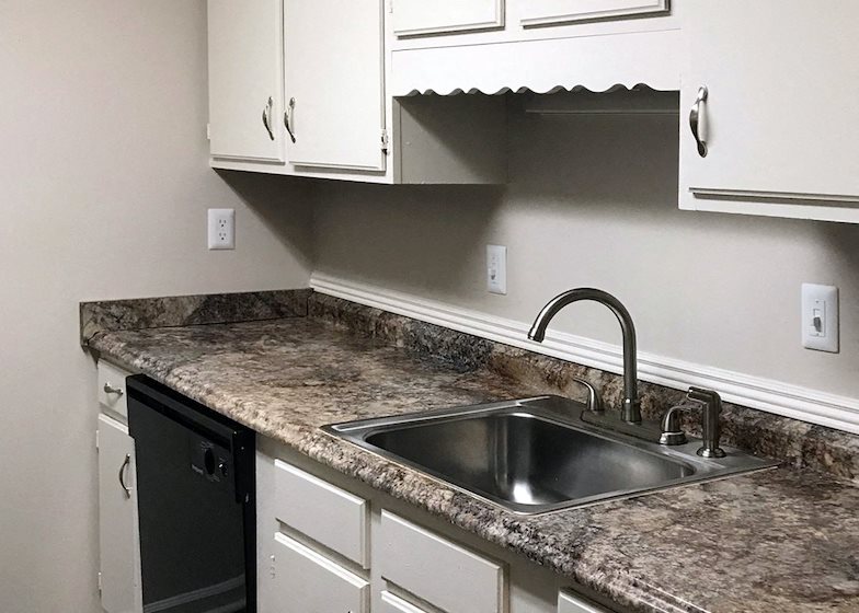 kitchen with granite-style countertops, stainless steel sink, and dishwasher