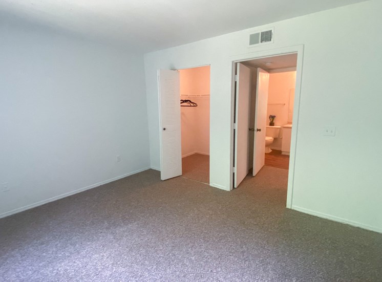 Carpeted Bedroom with folding closet door, bedroom door leads to hall and bathroom