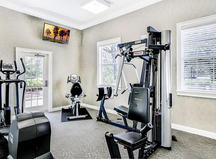 Fitness Center with cardio and strength machines with mounted tv on the wall
