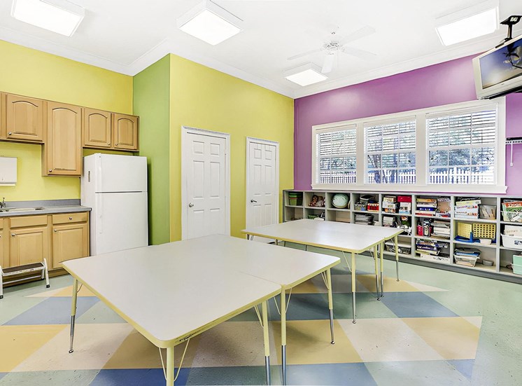 Activity center with tables, kitchenette, and bookshelves.