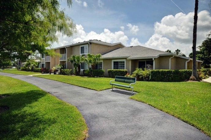Walking Path Surrounded By Green Grass at River Park Place Apartments, Florida