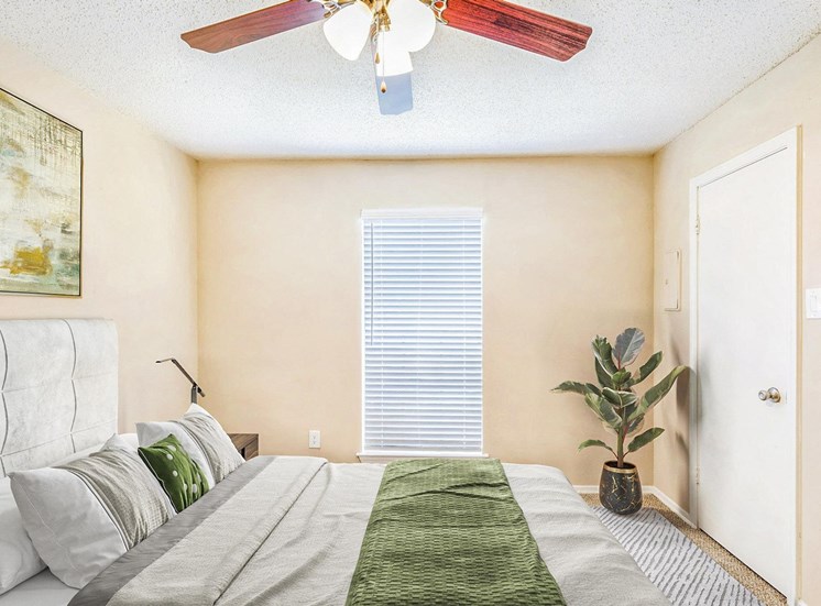 bedroom with queen size bed and large window  and ceiling fan