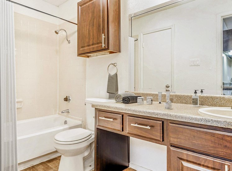 Bathroom with mirror above sink and towel rack. Bath tub with shower curtain.