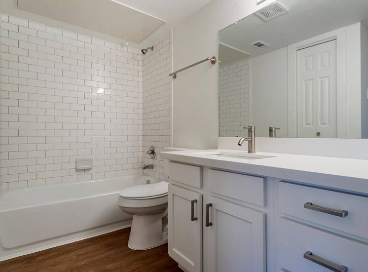 Bathroom with mirror above sink and towel rack. white cabinets