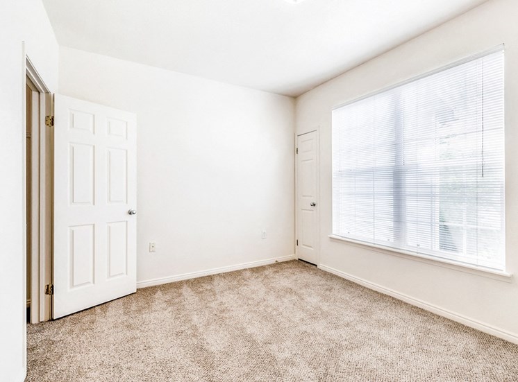 Bedroom with carpet flooring and windows for natural lighting