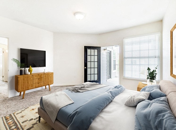 Model Room with Bed, Dresser Under Mounted Tv , Open Patio Door Next to Window