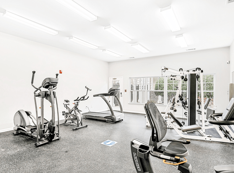 Bright Fitness Center with Exercise Equipment and Mirrored Wall and large window