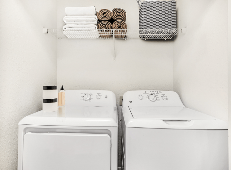 Virtually staged laundry area with shelf, towels, and basket