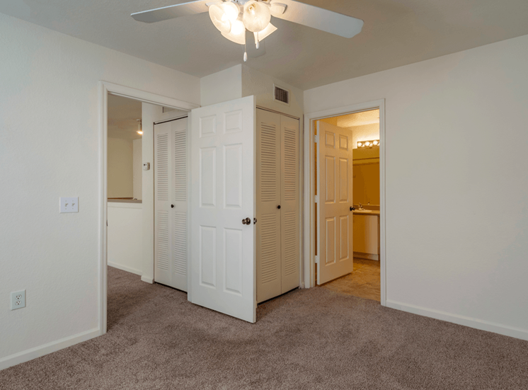 Bedroom with carpet flooring, multi speed ceiling fan, and in-suite bathroom