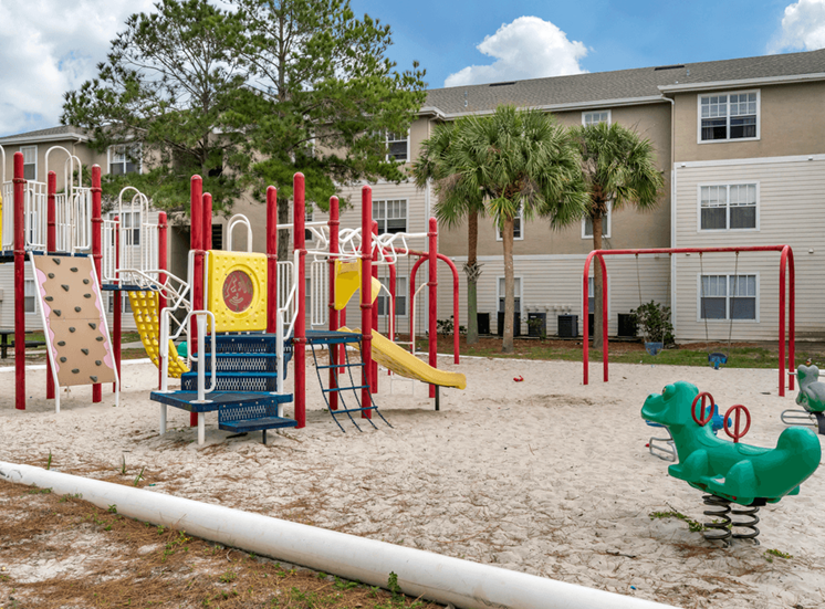 Outdoor playground with swing sets, slides, letters, and monkey bars
