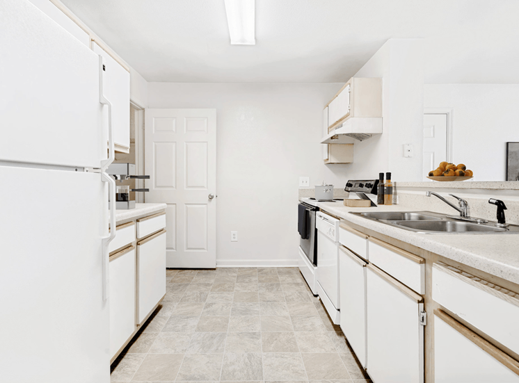 Virtually staged kitchen with tile floors and white appliances.