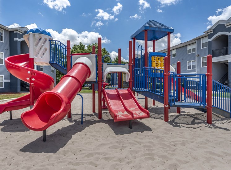 Outdoor playground equipped with two slides, monkey bars, and spiral latter