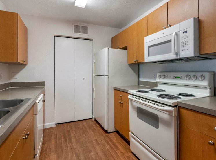 Fully equipped kitchen with hardwood style flooring, white appliances, and double basin sink