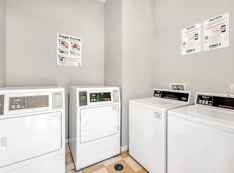 Laundry center with white washers and dryers.