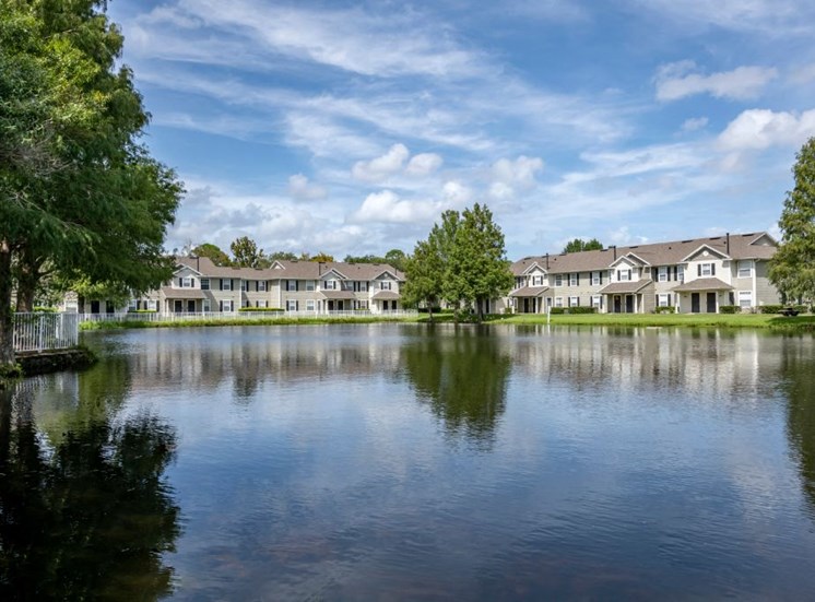 Apartment building exterior surrounded by native landscaping overlooking lake