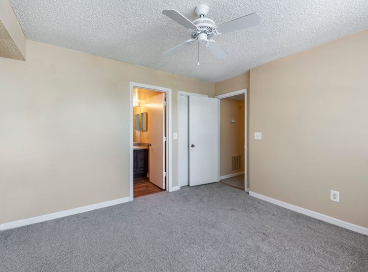 Bedroom with carpet flooring, multi speed ceiling fan, and in-suite bathroom