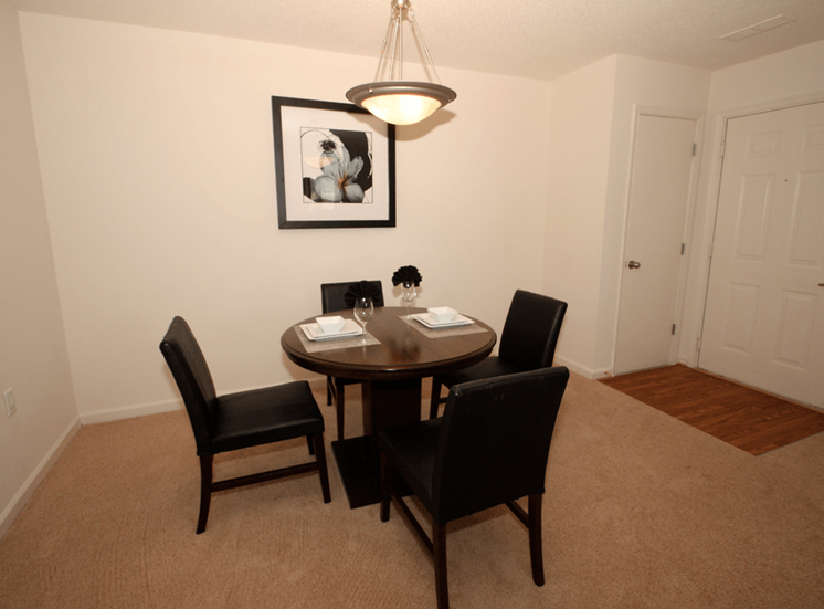 Dining room with carpet flooring, pendant lighting, and wall art