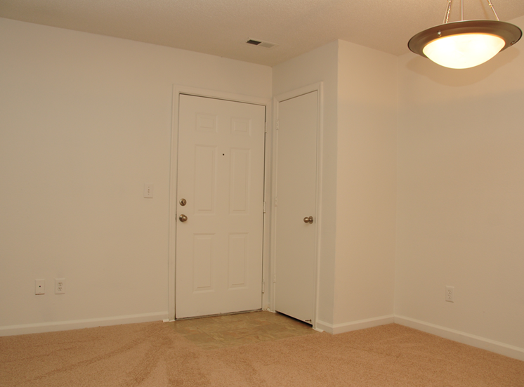 The entrance to the apartment has linoleum flooring and then wall to wall carpet. There is a coat closet just off the entry and overhead lighting in the dining room.