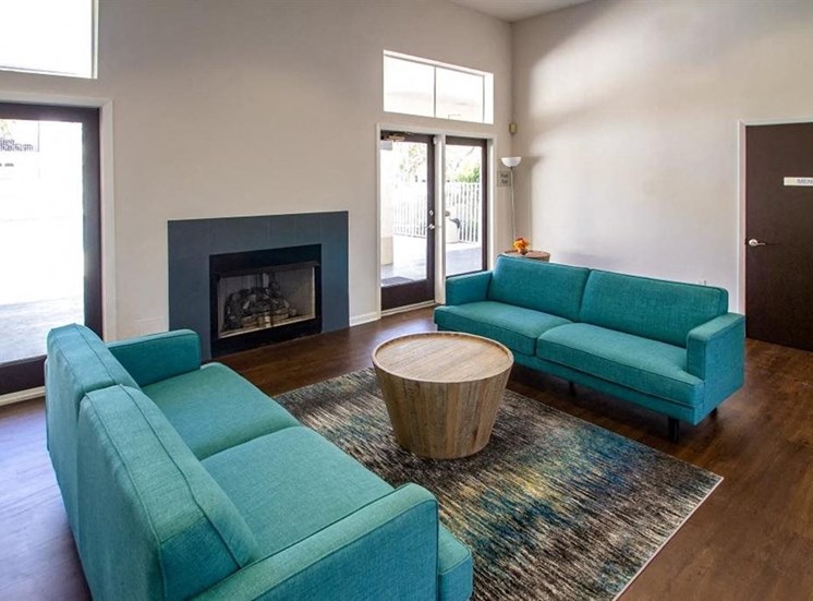 Interior leasing office seating area with two couches and fireplace