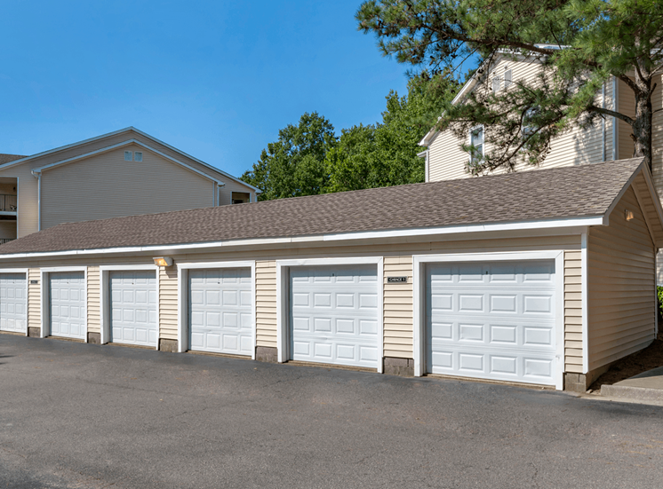 Detached Garages Next to Parking Lot with Trees in the Background