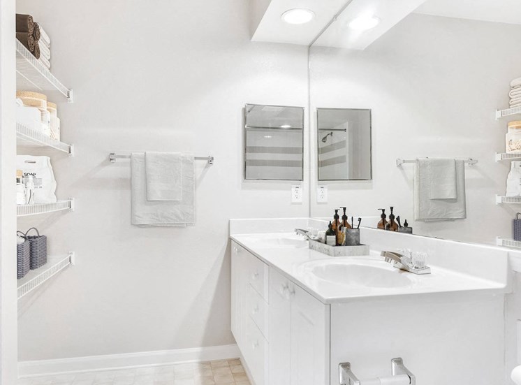Staged Bathroom with tile vinyl style floors, toilet, shower/tub combo and white cabinets. Towles, lotion, and organized containers used as décor