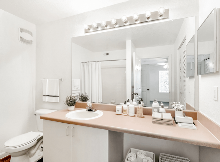 Virtually staged bathroom with large mirror, toilet, medicine cabinet
