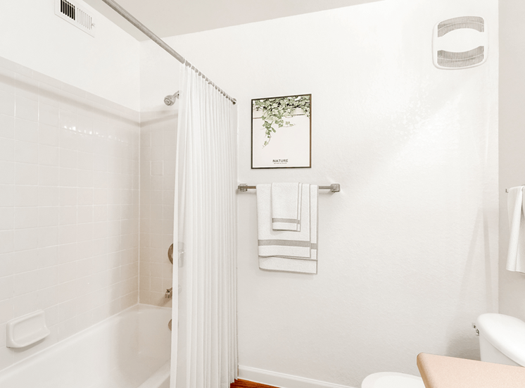 Virtually staged bathroom with tiled tub, shower curtain