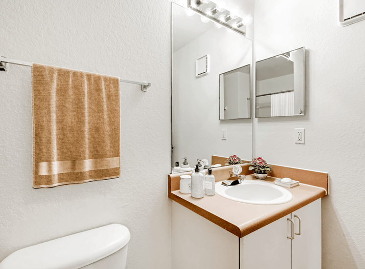 Virtually staged bathroom with large mirror, medicine cabinet, toilet, towel rack