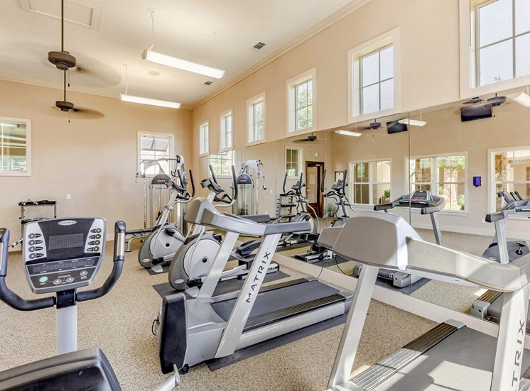 Fitness Center with Exercise Equipment and Mirror Accent Wall