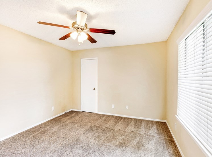 Bedroom with large window and ceiling fan