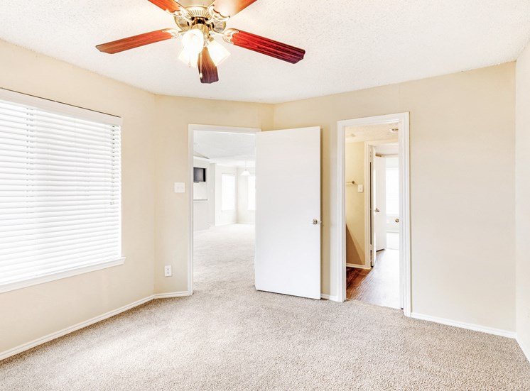 Carpeted bedroom with ceiling fan and en suite bathroom