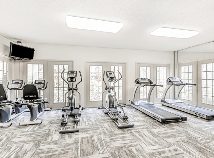 Fitness center with cardio machines, many windows and wall mounted television