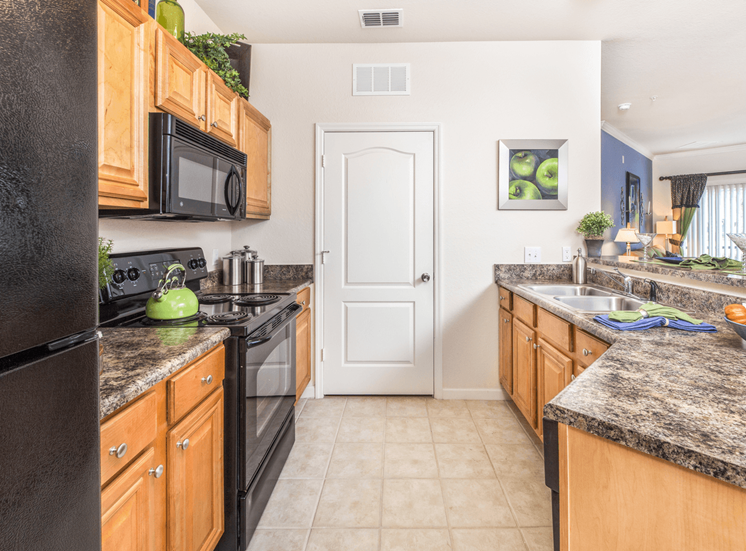 Fully equipped kitchen with black appliances and tiled flooring
