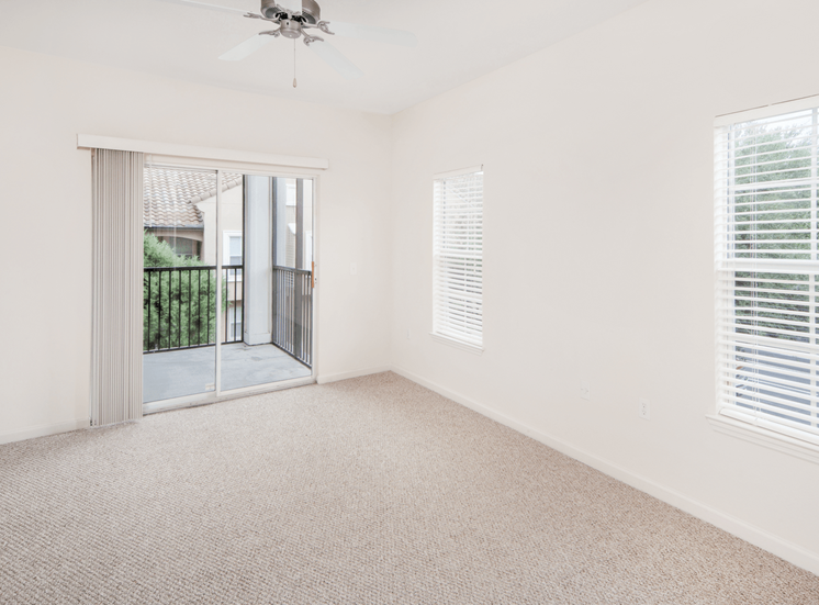 Spacious living room with carpet flooring and private balcony access
