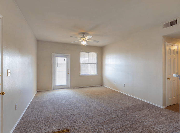 Livingroom with carpet, ceiling fan with light, entry way door, large window with mini blinds, and patio exit door