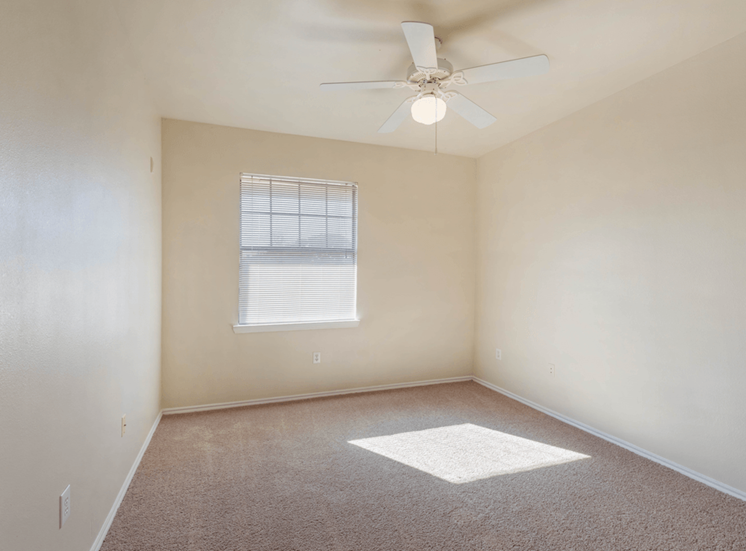 Bedroom with carpet, ceiling fan with light and window with mini blinds