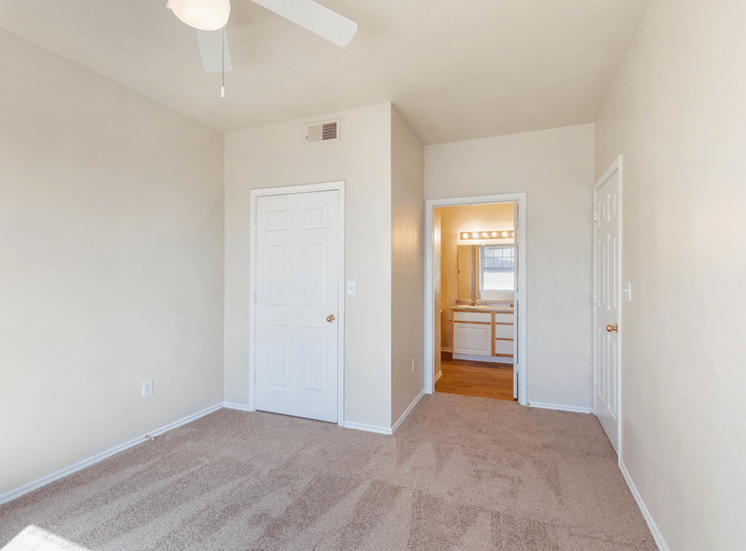 Bedroom carpet, ceiling fan with light, en suite bathroom and door to closet