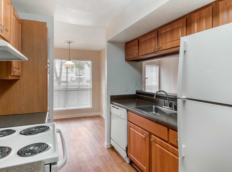 Fully equipped kitchen with white appliances and hardwood style flooring