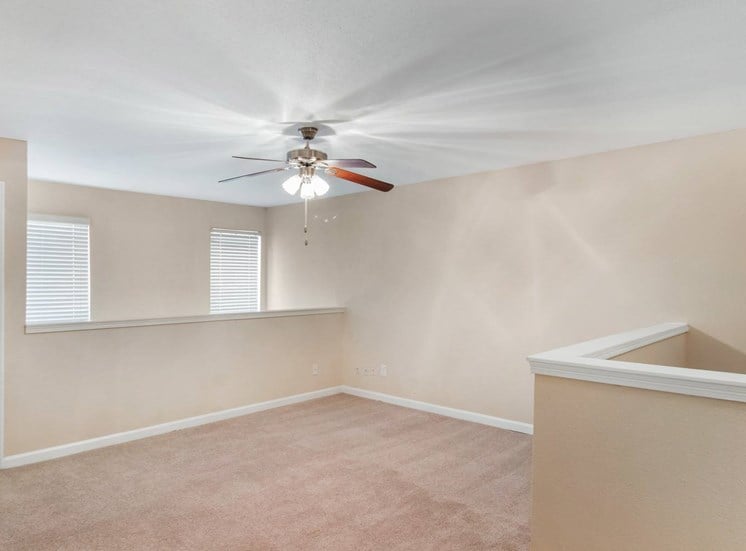 Living room with wall to wall carpet, ceiling fan, and white trim