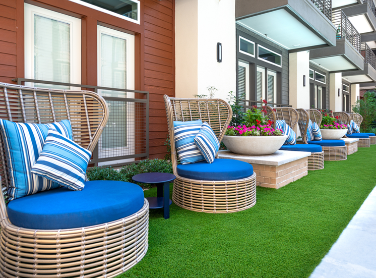 Outdoor seating area with artificial turf and building exterior surrounding