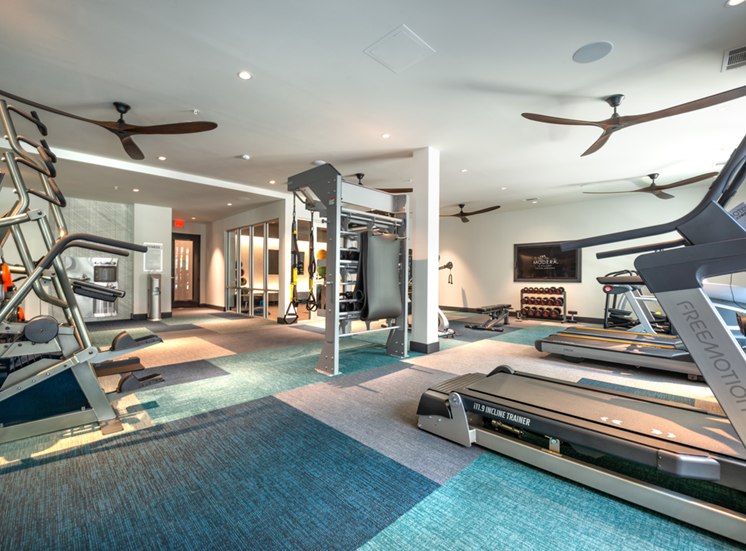 Fitness center with cardio and strength machines and wall mounted television