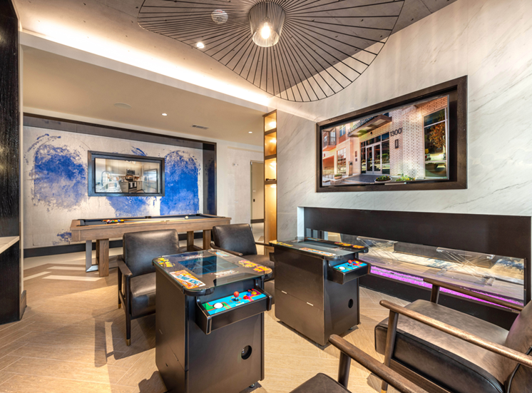Clubhouse game room with arcade, wall mounted televisions, fireplace and pool table